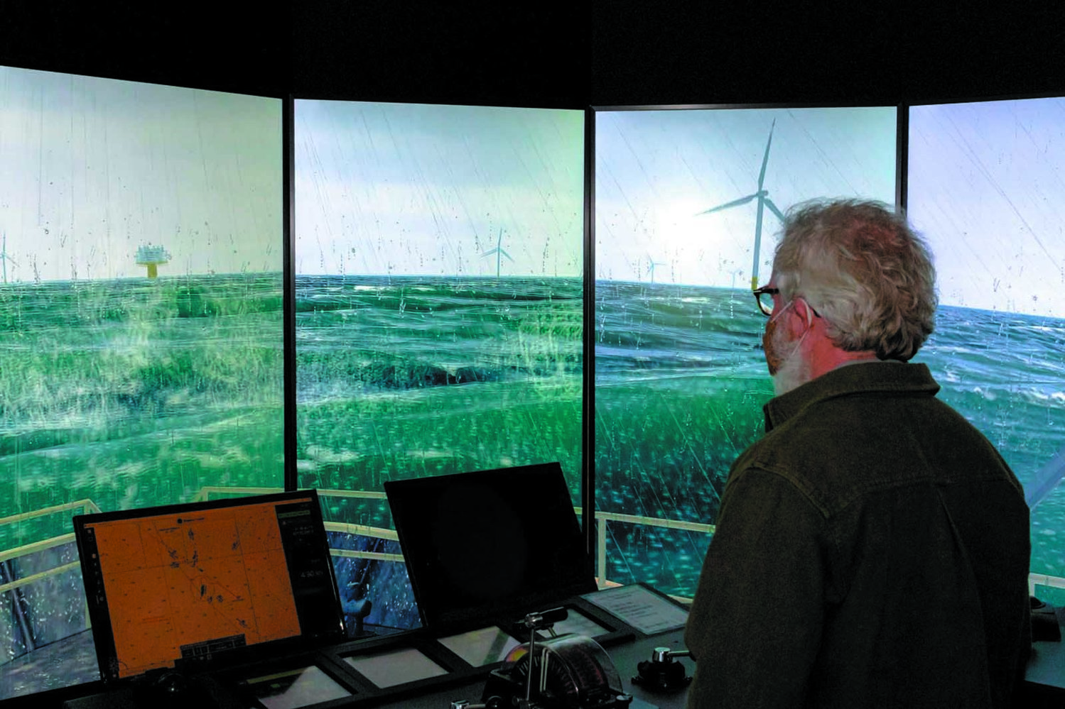 PILOTING IN WIND FARM: Todd Corayer, fishing guide and fishing writer, tries his hand at piloting through a wind farm in high seas, wind and rain at the Revolution wind farm simulator. (Submitted photos) Capt. Patrick Cassidy